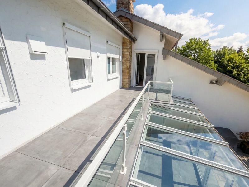 Balkongeländer aus Glas mit Einfassung aus Stahlrohrahmen in weiß pulverbeschichtet