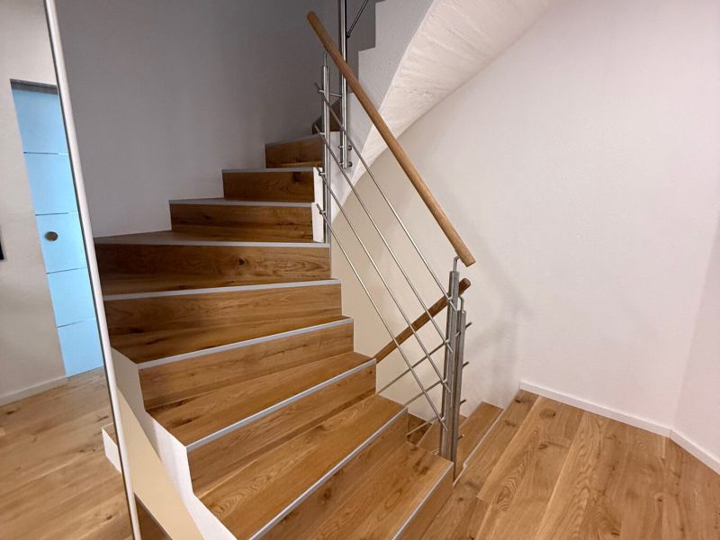 Treppe mit Parkett und Edelstahl Handlauf